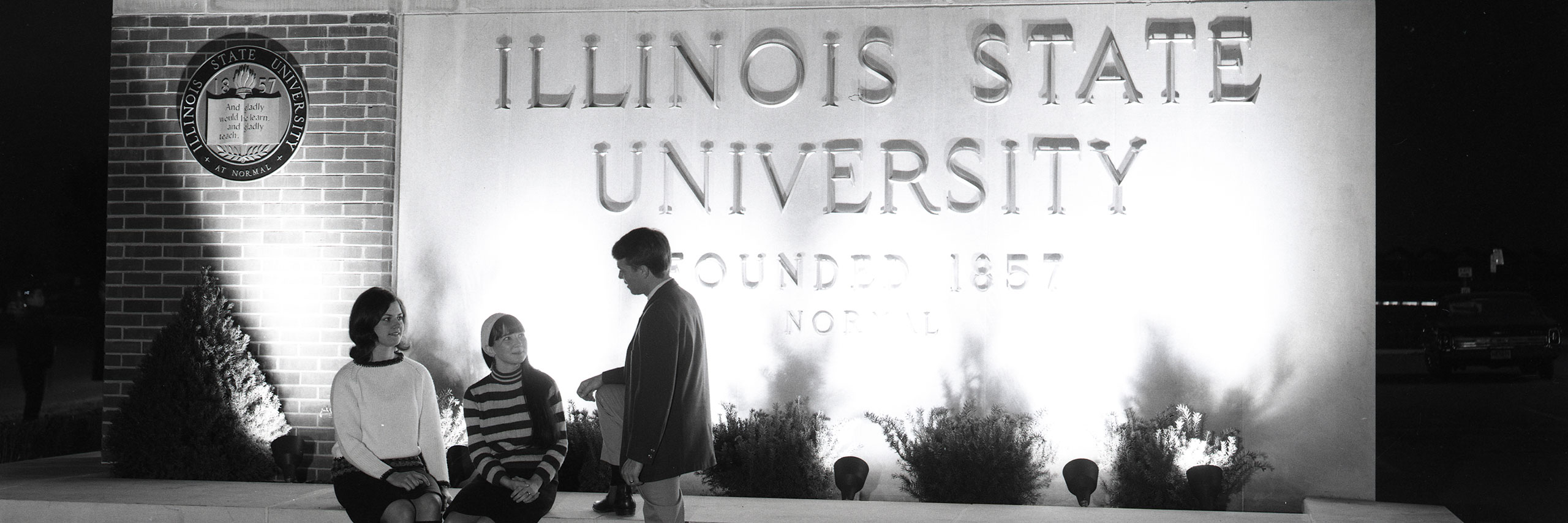 Students talking in front of the Illinois State sign